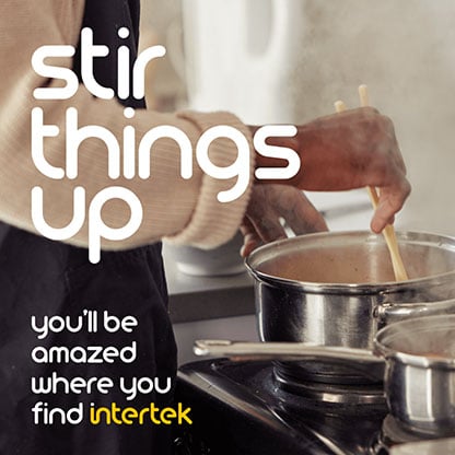 A cook stirring the contents of a pot on a stove