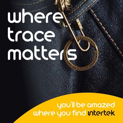 A decorative safety pin attached to the belt loop on a pair of denim pants