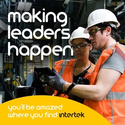 Two people wearing personal protection equipment while reading from a tablet